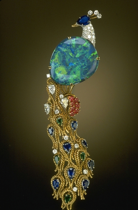 The Opal Peacock Brooch was designed by Harry Winston, Inc., and features a 32-carat black opal from Lightning Ridge, Australia. The opal is accented with sapphires, rubies, emeralds, and diamonds set in yellow gold. The Opal Peacock was donated to the National Gem Collection by Harry Winston in 1977.